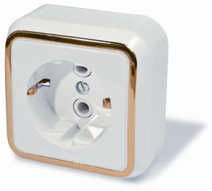 Розетка открытой установки одноместная, с заземлением и защитными шторками,серия Москвичка, цвет белый с рамкой под золото