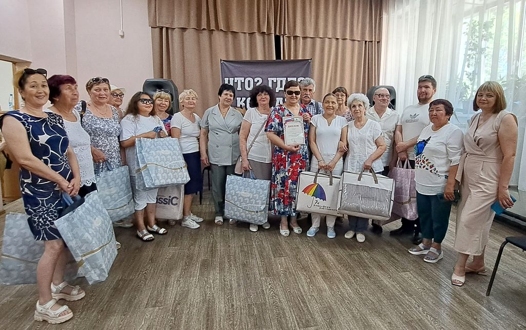 Групповое фото всех участников конкурса. В руках у них пакеты с подарками. Все улыбаются.