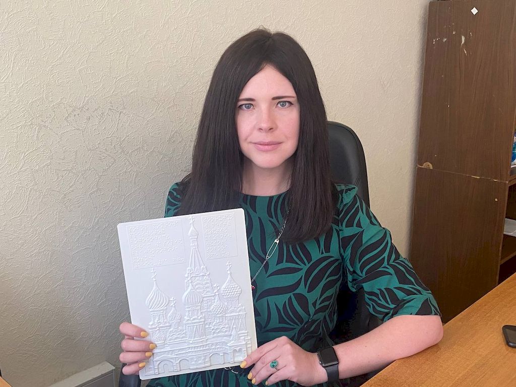 преподаватель тифлокомментирования Мария Щербакова держит в руке тактильное изображение